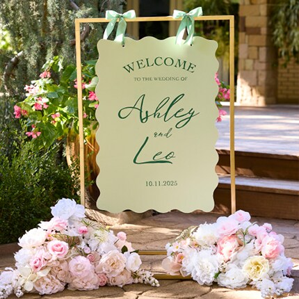 outdoor wedding sign with pink flower arrangements
