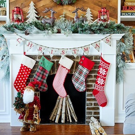 holiday mantle decorated with stockings, greenery and table decor