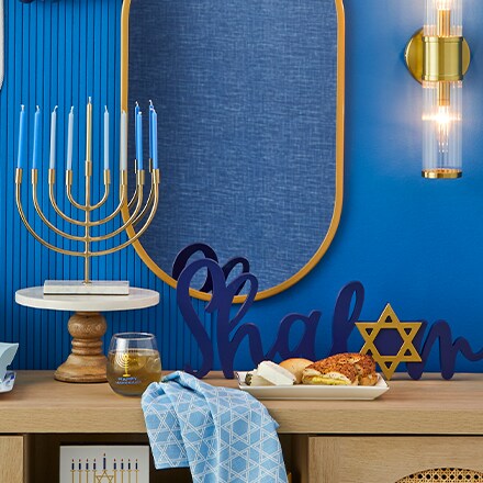 menorah and décor accents on wood buffet in front of blue wall