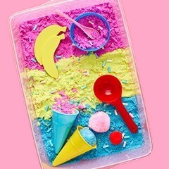 Pink, yellow, blue sand, with tools in the sand. 