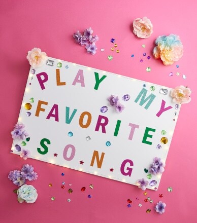 white poster with 'play my favorite song' in colorful letters