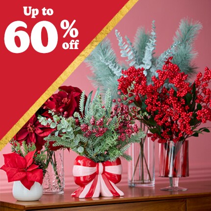 table with assorted vases with red and green florals with up to 50% off in white text over red triangle