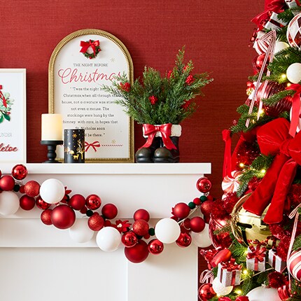 red wall with white mantel and red Christmas decorations