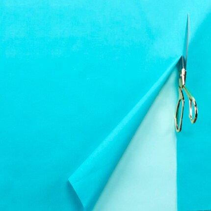 scissors cut halfway through blue fabric