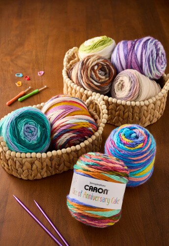 assorted caron cakes yarn skeins on wood table