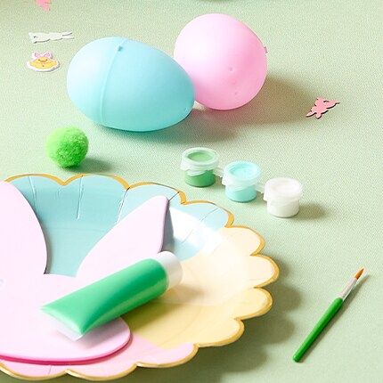 Easter craft paint on a plate over a green back ground. 